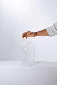 Hand holding glass against white background