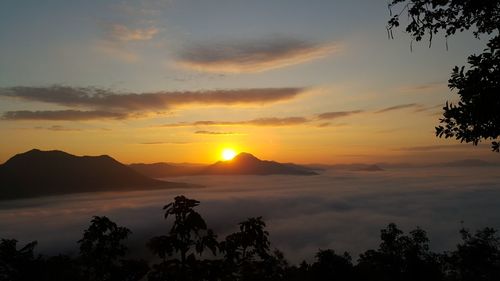 Scenic view of silhouette mountains against orange sky
