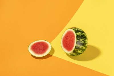 Mini watermelon section sliced on a yellow-orange background. watermelon interior in bright light.