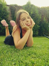 Portrait of smiling young woman sitting on grassy field