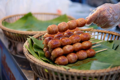 Close-up of hand holding food over basket