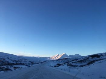 Scenic view of snowcapped mountains against clear blue sky