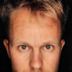 Midsection of young man with gray eyes against black background