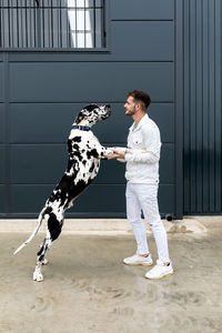 Full length of man with dog standing outdoors