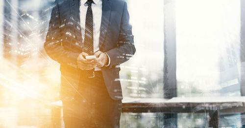 Digital composite image of businessman using mobile phone