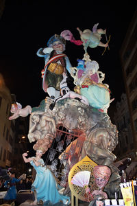 Low angle view of statue in city at night