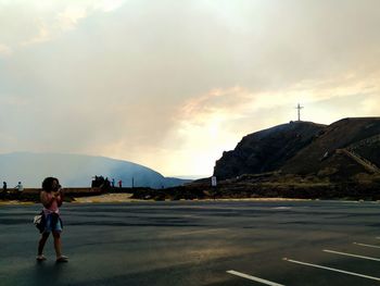 Full length of man standing on road against sky