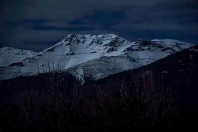 Scenic view of snowcapped mountains against sky at night