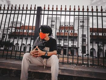 Full length of young man sitting on bench