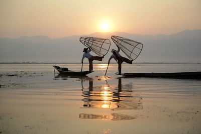 Two men with traditional fishing baskets