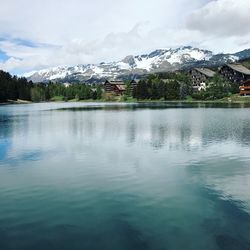 Scenic view of lake by mountains against sky