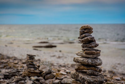 Stack of rocks at beach against sky