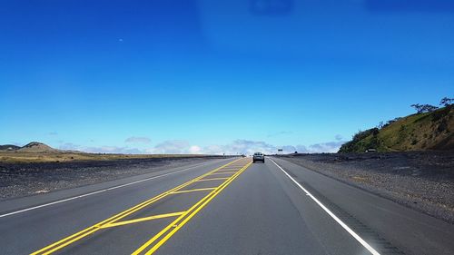 Road amidst landscape against clear blue sky