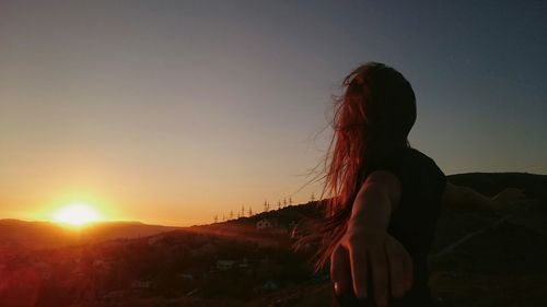 Silhouette of people on landscape at sunset