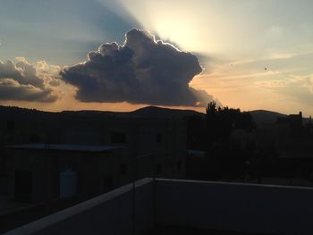 Silhouette buildings against sky during sunset