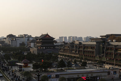 Buildings in city against sky during sunset