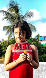 Cute girl standing on palm tree