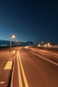 Light trails on road against sky at night