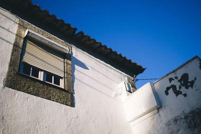 Low angle view of houses against blue sky