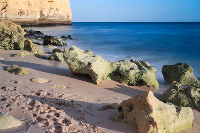 Scenic view of rocks on beach against sky