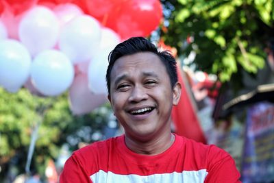 Portrait of smiling man against balloons