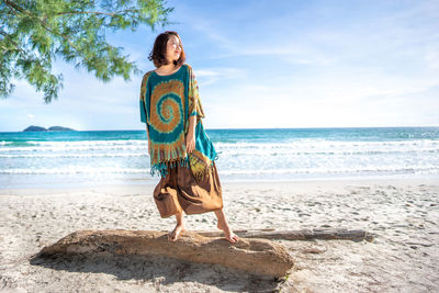 Full length of woman on beach against sky