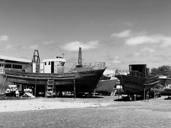 Boats moored on beach against sky