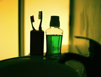 Close-up of bottle and toothbrush in bathroom