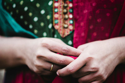 Midsection of woman in salwar kameez with hands clasped