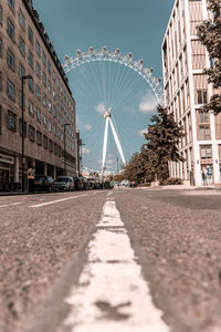 Surface level of road amidst buildings against sky