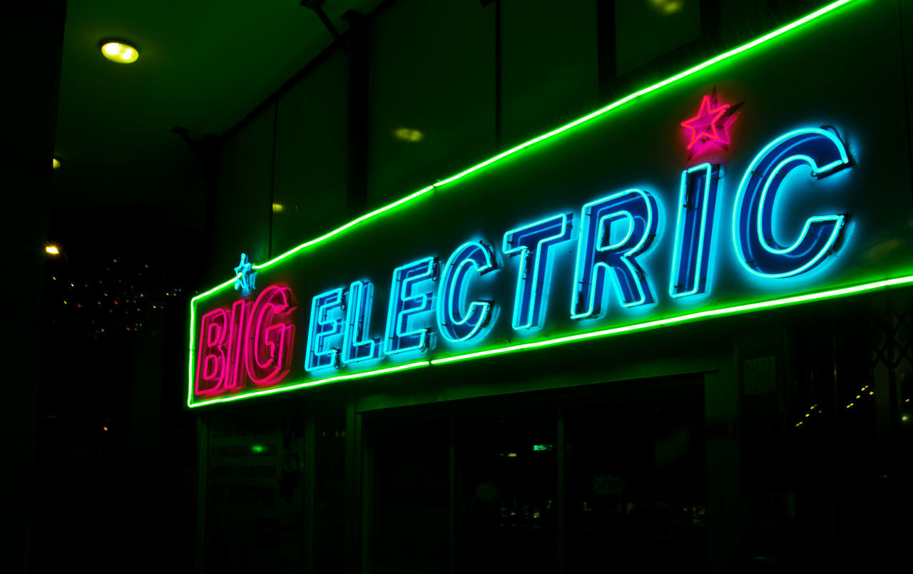 LOW ANGLE VIEW OF ILLUMINATED INFORMATION SIGN AT NIGHT