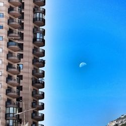 Low angle view of buildings against clear blue sky