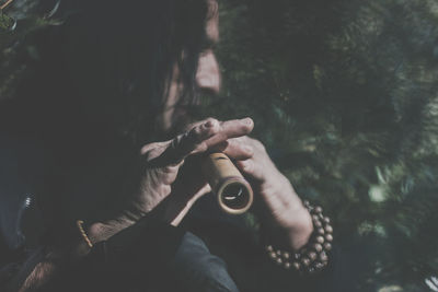 Man playing flute while standing in forest