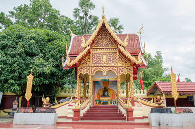 Temple by building against sky