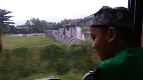 Portrait of boy looking away against plants