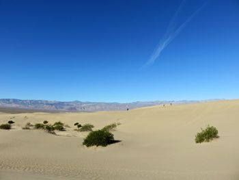 Scenic view of desert against blue sky