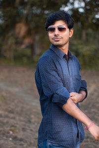 Young man wearing sunglasses standing outdoors