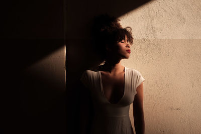 Teenage girl standing against wall