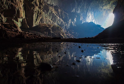 Reflection on lake in cave during sunny day