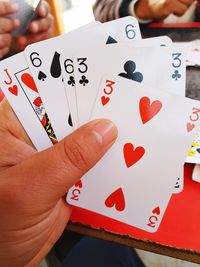 Close-up of hand holding heart shape on table