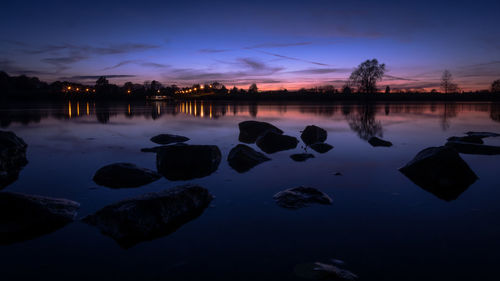 Scenic view of lake against sky at sunset