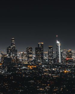 Illuminated cityscape against sky at night