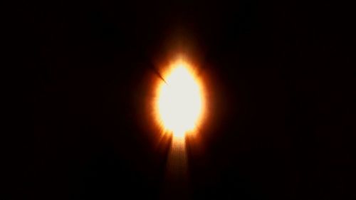 Close-up of illuminated candle against black background