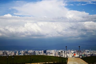 View of cityscape against cloudy sky