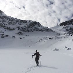 Man standing on snowcapped mountain against sky