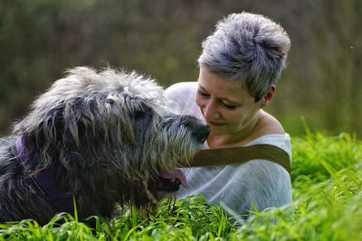 Close-up of woman with irish wolfhound on grassy field