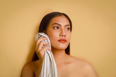 Portrait of a beautiful young woman against wall