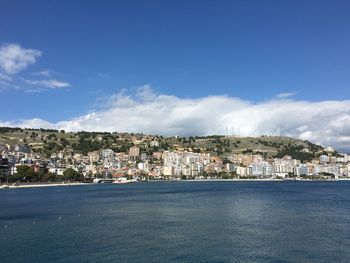 Scenic view of sea by town against sky