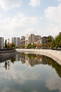 Scenic view of lake by buildings against sky