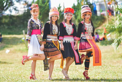 Rear view of women walking on grass